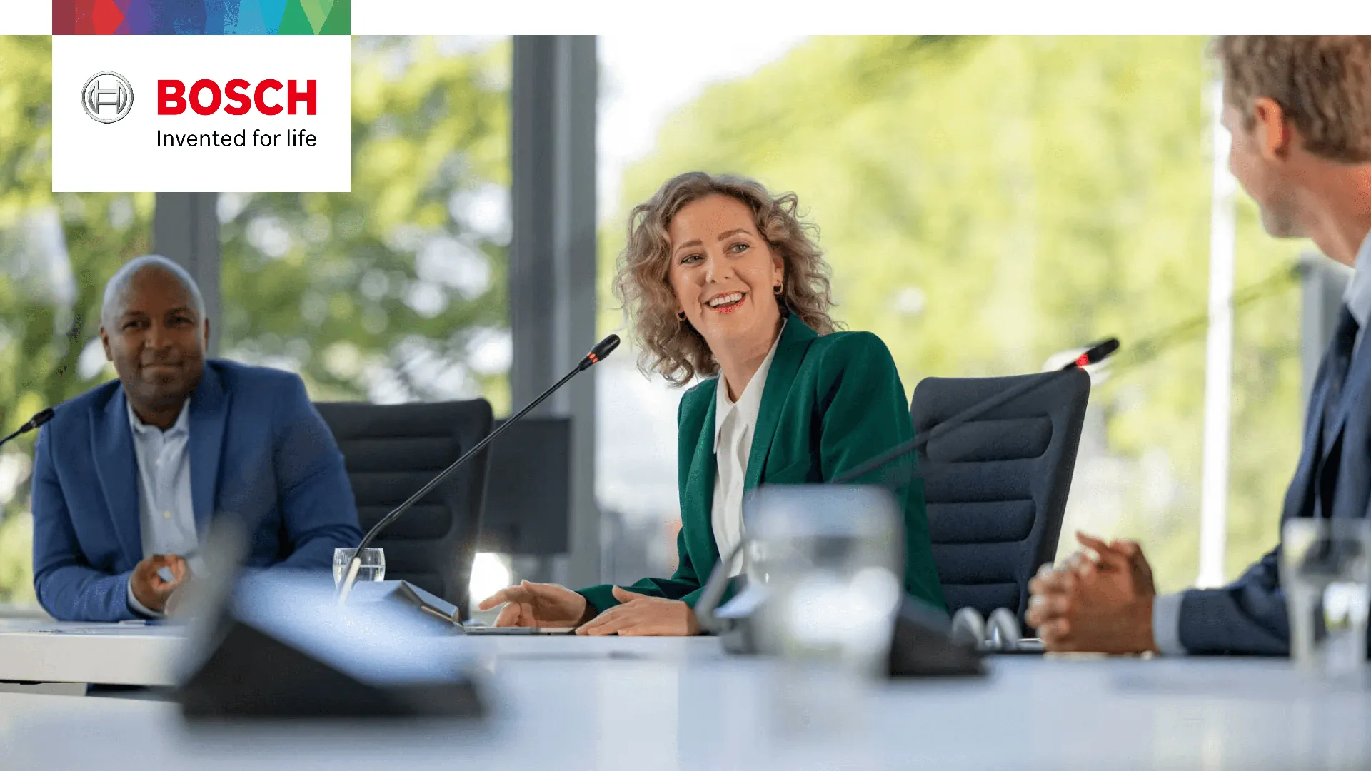 Bosch DICENTIS Flush conference microphones built into a meeting room table with delegates seated