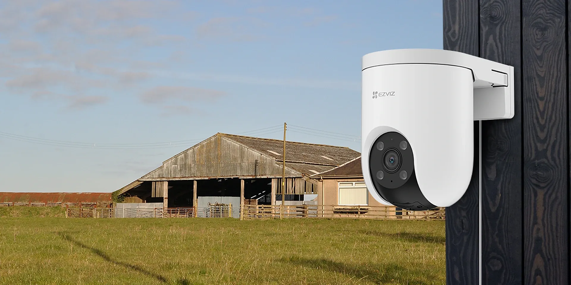 EZVIZ H8c 4G 2K pan and tilt 4G camera mounted on a wooden wall overlooking a farm