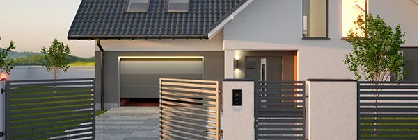 EZVIZ HP5 outdoor doorbell panel mounted on a gate pillar of a modern house